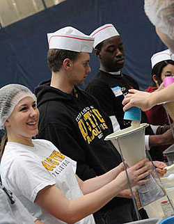 Students and others package meals for people in Darfur at the 2008 Building Bridges conference 'Kids Against Hunger' Food Packaging event. More than 48,000 meals were prepared. (Photo by Tom Roster)